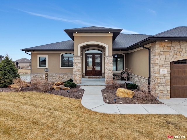 view of front facade featuring french doors, stone siding, and stucco siding