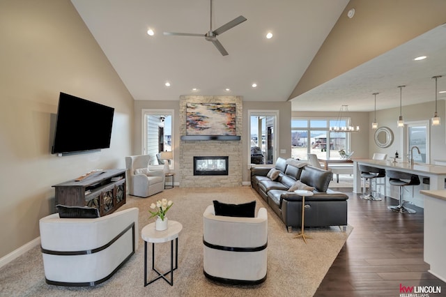 living room with dark wood-style flooring, a healthy amount of sunlight, a fireplace, and a ceiling fan