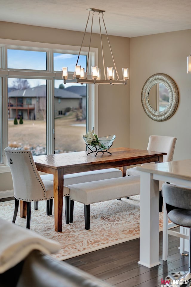 dining area with dark wood-style flooring and a chandelier