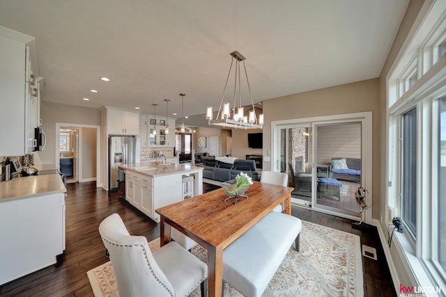 dining room with dark wood-type flooring, recessed lighting, and a chandelier