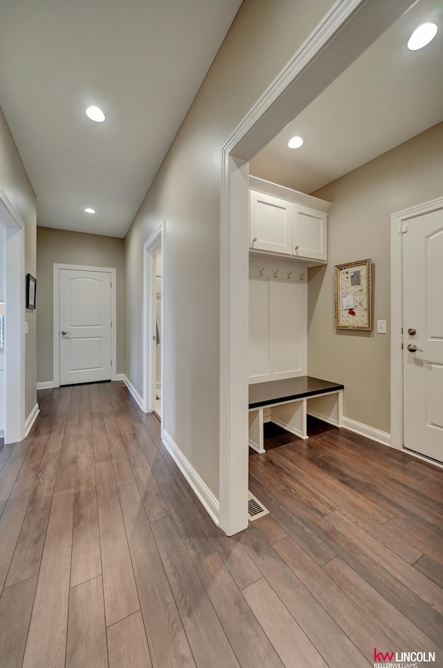 hall with baseboards and wood finished floors