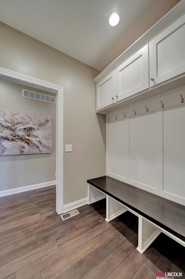 mudroom featuring dark wood finished floors, visible vents, and baseboards