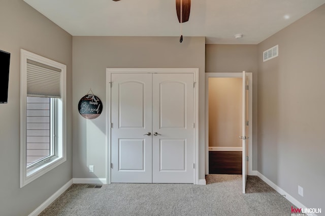 unfurnished bedroom featuring carpet, visible vents, and baseboards