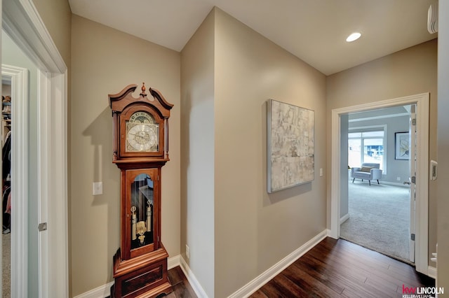 hall featuring recessed lighting, baseboards, and dark wood-style flooring