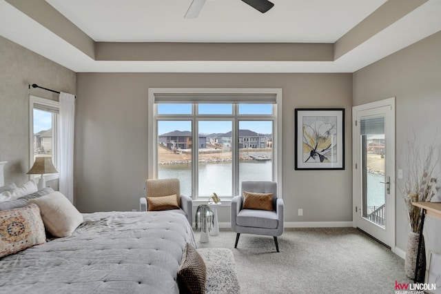 bedroom with carpet, baseboards, ceiling fan, access to exterior, and a water view