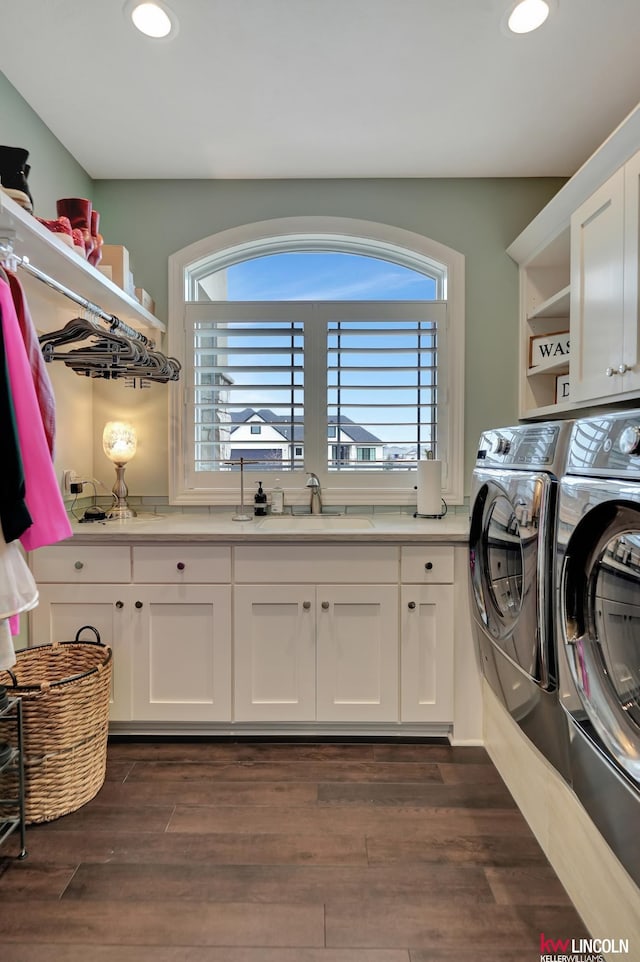 washroom featuring washing machine and clothes dryer, dark wood finished floors, recessed lighting, cabinet space, and a sink