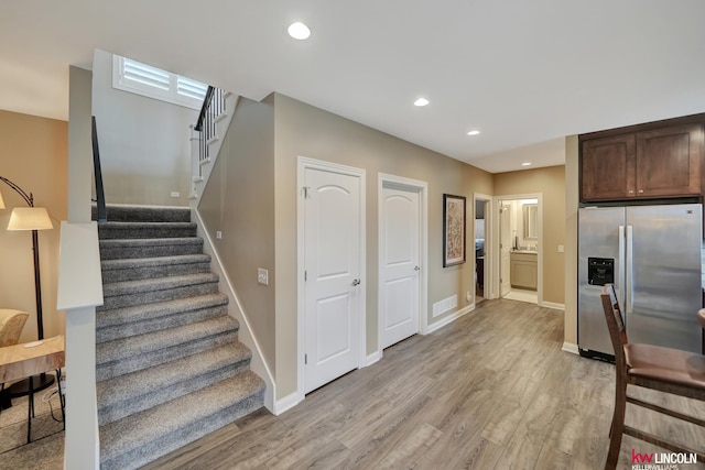 staircase with visible vents, recessed lighting, wood finished floors, and baseboards