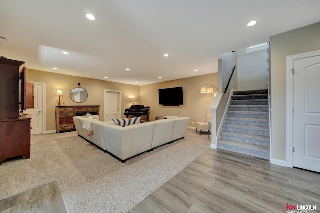 living area featuring recessed lighting, stairs, and baseboards