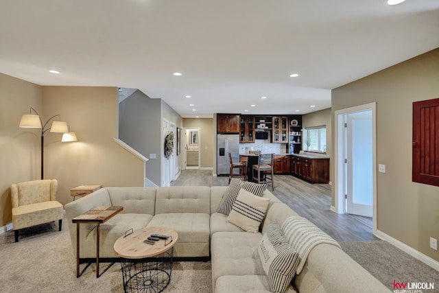 living area with recessed lighting, baseboards, and light wood-style floors