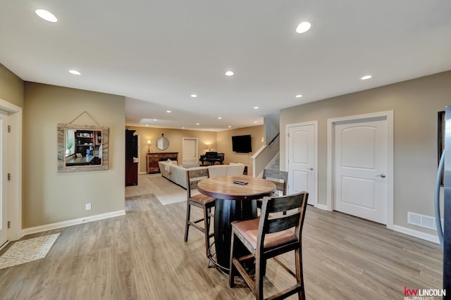 dining room with stairs, light wood-style flooring, recessed lighting, and visible vents