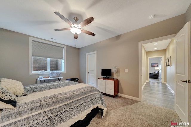 bedroom featuring baseboards, light carpet, visible vents, and a ceiling fan