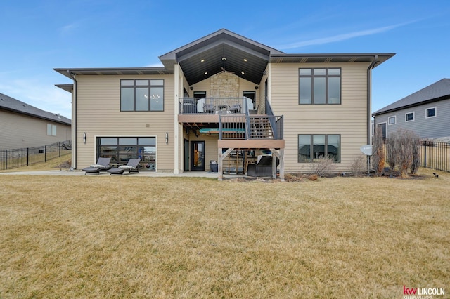 rear view of property featuring a fenced backyard, a yard, a garage, stairs, and a patio area