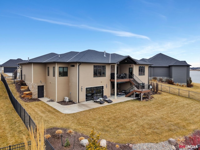 rear view of property featuring a patio, stairway, a fenced backyard, and a lawn