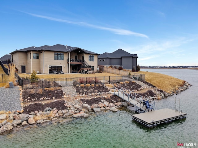 dock area with a patio, stairway, fence private yard, and a water view