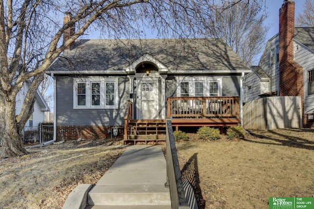 view of front of property with a gate, a wooden deck, roof with shingles, and fence