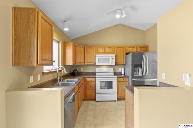 kitchen featuring light tile patterned floors, a sink, stainless steel appliances, vaulted ceiling, and dark countertops