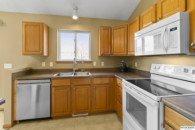 kitchen with a sink, visible vents, white appliances, and dark countertops