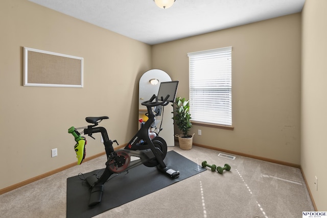 exercise area featuring carpet, visible vents, and baseboards