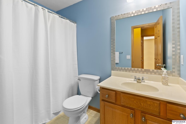 bathroom featuring tile patterned flooring, toilet, and vanity