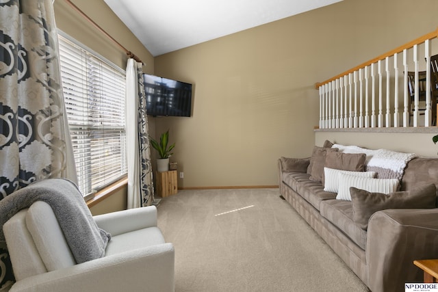 carpeted living room featuring vaulted ceiling and baseboards