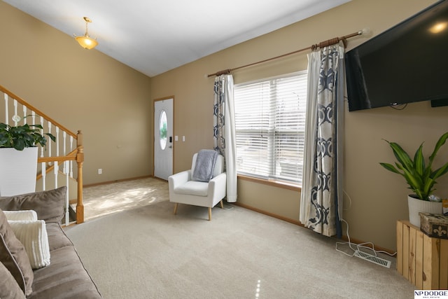 living area with stairway, baseboards, carpet, and vaulted ceiling