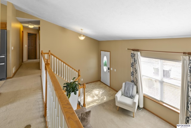 foyer entrance featuring baseboards and light colored carpet