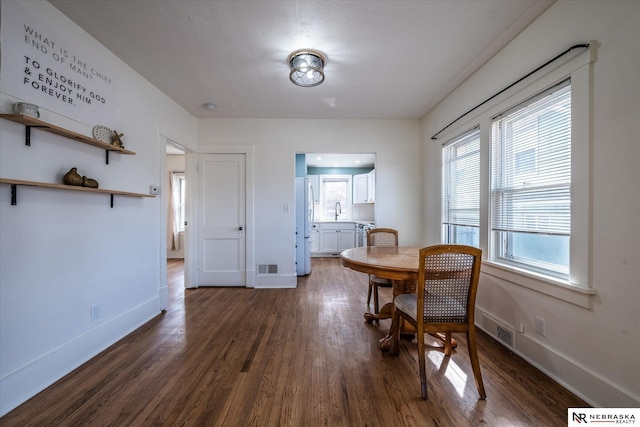 dining room with visible vents, baseboards, and dark wood-style flooring