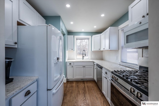 kitchen featuring decorative backsplash, white cabinets, dark wood-style flooring, and stainless steel appliances