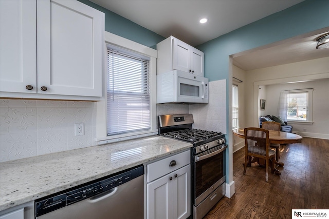 kitchen featuring dark wood finished floors, white cabinetry, backsplash, and stainless steel appliances