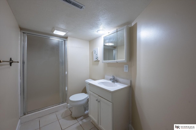 full bath with toilet, a stall shower, a textured ceiling, tile patterned flooring, and vanity