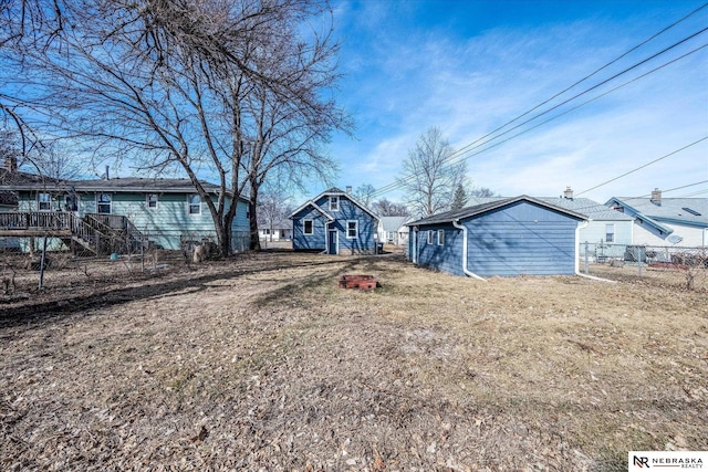 view of yard featuring an outbuilding, stairway, and fence