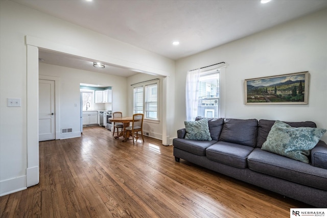 living area featuring recessed lighting, visible vents, baseboards, and dark wood-style floors