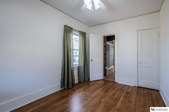 unfurnished bedroom featuring dark wood-style floors, visible vents, a ceiling fan, and baseboards