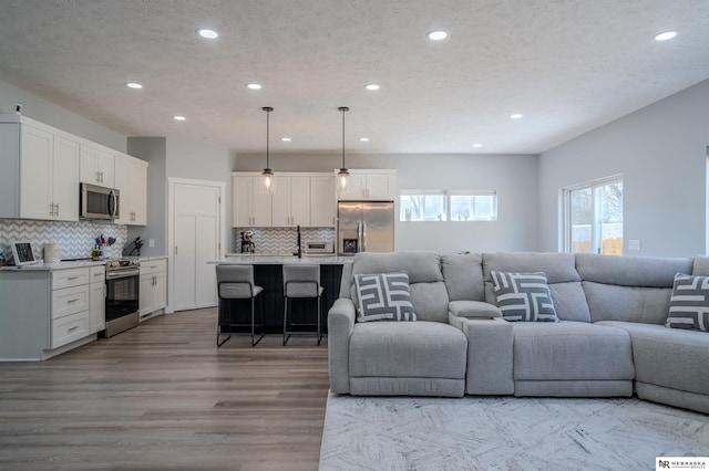 living area featuring recessed lighting, wood finished floors, and a textured ceiling