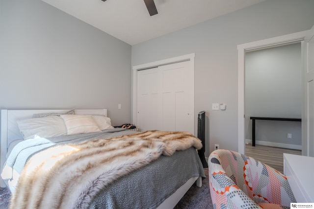 bedroom with a closet, wood finished floors, and a ceiling fan