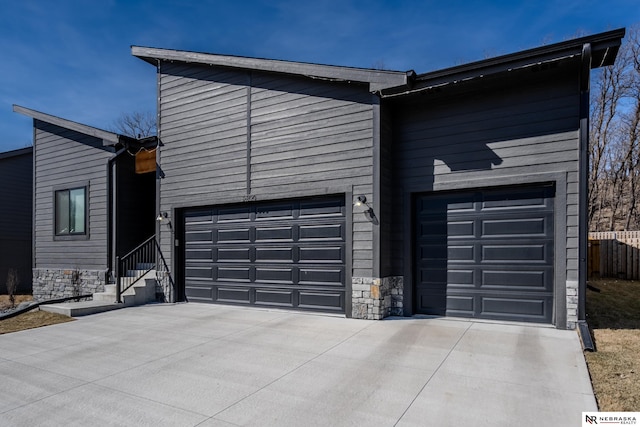 garage featuring fence and driveway