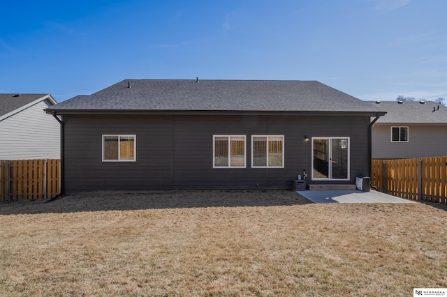 rear view of property with a yard, a patio, a fenced backyard, and a shingled roof