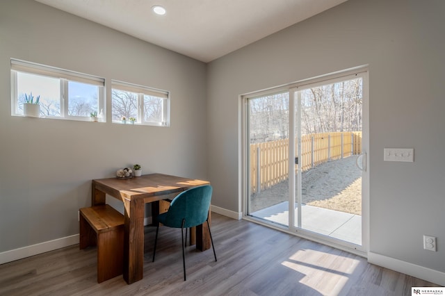 dining area with baseboards and wood finished floors