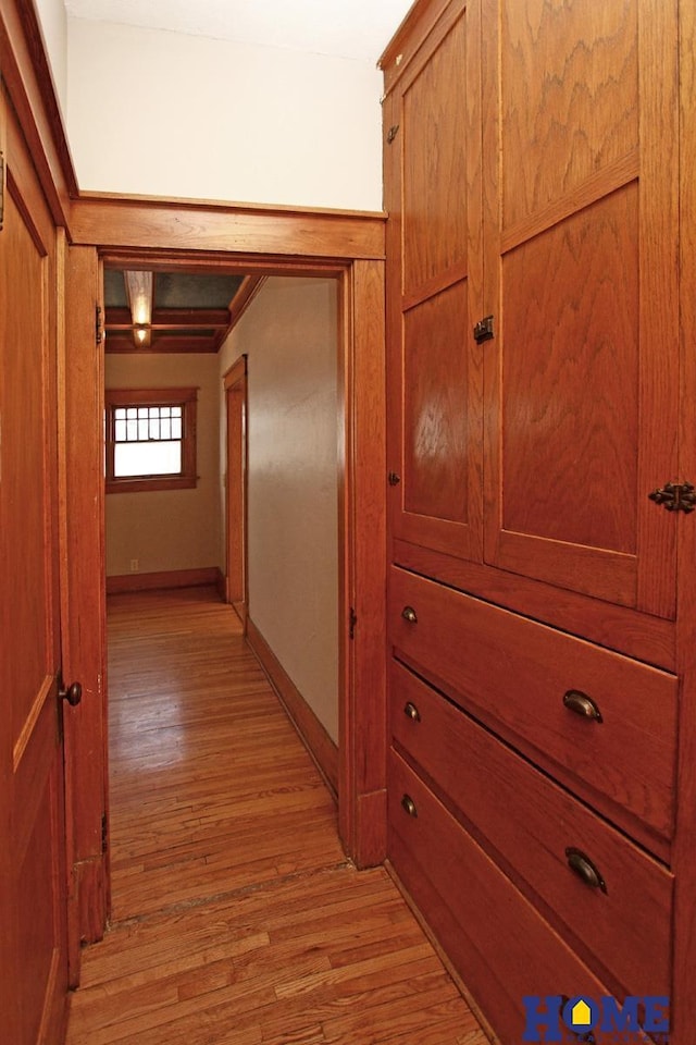 hall with baseboards and light wood-type flooring