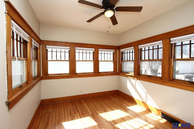 unfurnished sunroom with a ceiling fan and visible vents