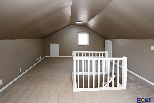 additional living space with baseboards and lofted ceiling