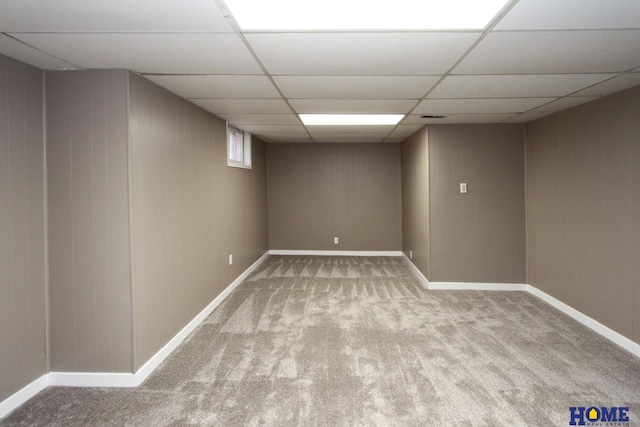 finished basement featuring carpet flooring, baseboards, and a drop ceiling