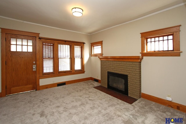 unfurnished living room featuring visible vents, a brick fireplace, ornamental molding, and carpet flooring