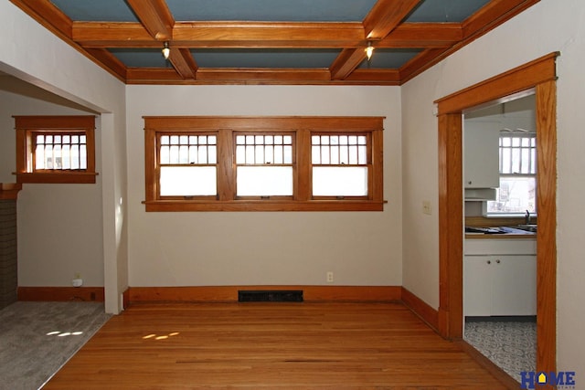 interior space featuring visible vents, baseboards, coffered ceiling, and beam ceiling