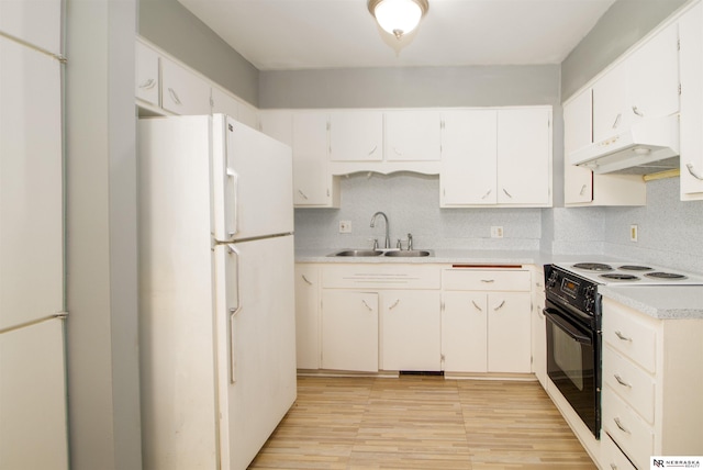 kitchen featuring freestanding refrigerator, a sink, light countertops, black range with electric cooktop, and under cabinet range hood