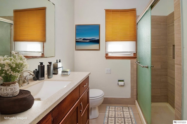 bathroom with tile patterned floors, toilet, a shower stall, baseboards, and vanity