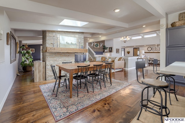 dining space with beamed ceiling, wood finished floors, recessed lighting, a skylight, and baseboards