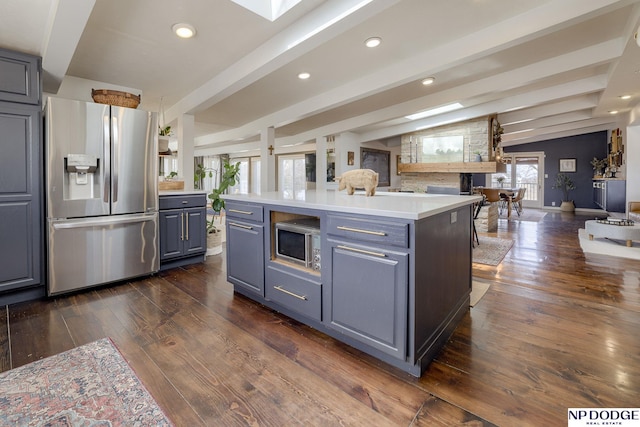 kitchen featuring vaulted ceiling with beams, open floor plan, light countertops, dark wood-style floors, and stainless steel appliances