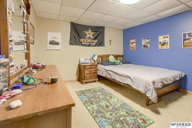 carpeted bedroom with baseboards and a paneled ceiling