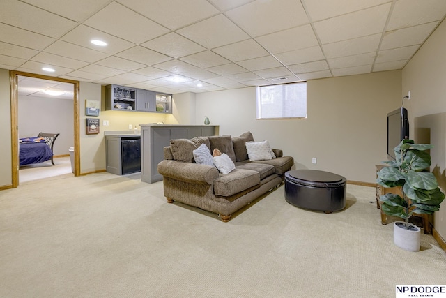 living room featuring light colored carpet, a dry bar, a paneled ceiling, and baseboards